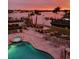 Community pool and waterfront in the evening featuring chairs and sunset views at 516 Tamiami S Trl # 303, Nokomis, FL 34275