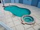 An inviting outdoor swimming pool with an adjacent hot tub, surrounded by a tiled patio and lush greenery at 516 Tamiami S Trl # 303, Nokomis, FL 34275