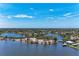 Scenic aerial view of a waterfront community with charming homes, serene waterways, and lush vegetation under a blue sky at 5207 5Th Avenue Nw Dr, Bradenton, FL 34209