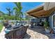 Inviting backyard with covered patio, pool, seating, grill, and lush landscaping at 5207 5Th Avenue Nw Dr, Bradenton, FL 34209