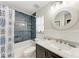 Stylish bathroom with tiled shower, a round mirror, and marble countertop sink at 5207 5Th Avenue Nw Dr, Bradenton, FL 34209