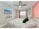 Bright bedroom with a ceiling fan, beach view on TV, and light hardwood floors at 5207 5Th Avenue Nw Dr, Bradenton, FL 34209