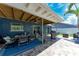 Covered patio with seating for six, fan, grill, and sliding glass doors at 5207 5Th Avenue Nw Dr, Bradenton, FL 34209