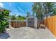 Backyard shed with double doors and fenced-in storage area at 5207 5Th Avenue Nw Dr, Bradenton, FL 34209
