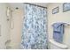 Bathroom featuring a shower/tub combo with blue floral curtains, grab bars, and blue towels at 708 Tamiami S Trl # 115, Venice, FL 34285
