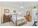 Bedroom with beach decor, a four-poster bed with blue bedding, and matching wooden dressers at 708 Tamiami S Trl # 115, Venice, FL 34285