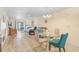 Open-concept living room with a glass dining table and plenty of natural light at 708 Tamiami S Trl # 115, Venice, FL 34285