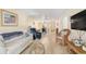 Cozy living room featuring comfortable seating, light wood floors, and a glimpse into the dining area at 708 Tamiami S Trl # 115, Venice, FL 34285
