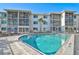Community pool surrounded by comfortable deck and white apartment building at 708 Tamiami S Trl # 115, Venice, FL 34285