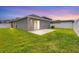 Spacious backyard with a well-maintained lawn and a cozy patio area, enclosed by a white fence at 711 Brenton Leaf Dr, Ruskin, FL 33570
