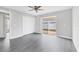 Bedroom features gray vinyl floors, a ceiling fan, and closet and sliding glass door to the backyard at 711 Brenton Leaf Dr, Ruskin, FL 33570