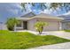 Charming single-story home with well-manicured lawn and a two car garage at 711 Brenton Leaf Dr, Ruskin, FL 33570