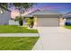 Beautiful home with lush green lawn, well-kept landscaping, and a large driveway leading to a garage at 711 Brenton Leaf Dr, Ruskin, FL 33570