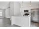 Kitchen with stainless steel appliances, white cabinets, quartz countertops and hanging pendant lights at 711 Brenton Leaf Dr, Ruskin, FL 33570