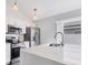 The modern kitchen features stainless steel appliances, a center island, and quartz countertops at 711 Brenton Leaf Dr, Ruskin, FL 33570