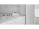 Inside laundry room features a white washer and dryer and white shelving for storage at 711 Brenton Leaf Dr, Ruskin, FL 33570