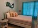 Charming bedroom with colorful bedding, wicker furniture, and bright blue sheer curtains at 7201 L Pavia Blvd # 7201, Venice, FL 34292