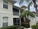 Exterior elevation of a two story condominium with mature landscaping and stairs to the upper units at 7201 L Pavia Blvd # 7201, Venice, FL 34292