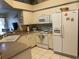 Kitchen with white appliances, breakfast bar and tile flooring at 7201 L Pavia Blvd # 7201, Venice, FL 34292