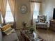 Comfortable living room with sofa, armchair, coffee table, and natural light filtering through the curtained windows at 7201 L Pavia Blvd # 7201, Venice, FL 34292
