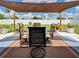 Outdoor patio table and chairs, covered by a shade structure, overlooks the manicured fenced yard at 7505 Wexford St, North Port, FL 34287