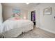 A bright bedroom featuring neutral colors, a large bed, and a closet with louvered doors at 7505 Wexford St, North Port, FL 34287