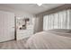 This bedroom features a neutral decor, a dresser, and an entry to the en suite bathroom at 7505 Wexford St, North Port, FL 34287