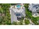 Aerial view of the home, showing its unique roof, outdoor pool, mature trees, and circular driveway at 755 Eagle Point Dr, Venice, FL 34285