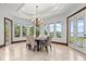 Bright dining room with large windows overlooking the water, chandelier, and seating for six at 755 Eagle Point Dr, Venice, FL 34285