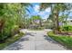 Circular driveway leading to a beautiful two-story home, surrounded by lush greenery and mature trees at 755 Eagle Point Dr, Venice, FL 34285