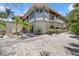 View of the home featuring a beautiful exterior, ample lighting, and tropical landscaping at 755 Eagle Point Dr, Venice, FL 34285