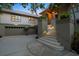 Twilight view of home featuring an attached three-car garage, grand entrance stairs with upward lighting at 755 Eagle Point Dr, Venice, FL 34285
