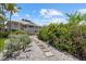 Home exterior with lush landscaping and stepping stones to the backyard and outdoor entertainment area at 755 Eagle Point Dr, Venice, FL 34285