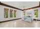 Bright main bedroom featuring large windows, tray ceiling, and tiled floors at 755 Eagle Point Dr, Venice, FL 34285