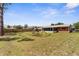 Spacious backyard featuring a wooden swing set, lush lawn, and fenced perimeter for privacy at 7582 Lyncrest St, North Port, FL 34287
