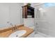 Bright bathroom showcasing vanity with stone top, cabinet, toilet, and glass-enclosed shower with shelving at 7582 Lyncrest St, North Port, FL 34287