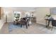 Inviting living room featuring tile floors and neutral walls, with sliding glass doors and view to dining area at 7582 Lyncrest St, North Port, FL 34287