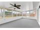 Large sunroom offering lots of natural light, ceiling fan, carpeted floors and doors to the backyard at 7582 Lyncrest St, North Port, FL 34287