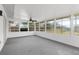 Spacious sunroom with paneled walls, fan, carpeting, and multiple windows letting in plenty of natural light at 7582 Lyncrest St, North Port, FL 34287