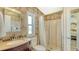 Tiled bathroom featuring a shower, cherry vanity and sink, a toilet, and a window at 763 Lakeside Dr, North Port, FL 34287