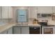 Cozy kitchen featuring essential appliances, white cabinetry, and a functional layout at 763 Lakeside Dr, North Port, FL 34287