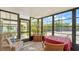 Inviting sunroom with multiple windows, comfortable seating, and views of the lush surroundings at 763 Lakeside Dr, North Port, FL 34287