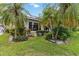 Lush backyard featuring tropical landscaping, vibrant plants, and a manicured lawn, enhancing the home's appeal at 1110 Southlake Ct, Venice, FL 34285