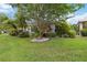 Lush backyard featuring mature trees, a manicured lawn, and vibrant landscaping, enhancing the home's appeal at 1110 Southlake Ct, Venice, FL 34285