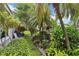 Lush backyard with tropical landscaping, mature trees, and a manicured lawn, enhancing the home's appeal at 1110 Southlake Ct, Venice, FL 34285