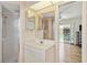 Bathroom with glass shower, vanity with large mirror, and view into adjacent bedroom at 1110 Southlake Ct, Venice, FL 34285