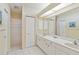 Bathroom featuring a double vanity, large mirror, and a separate shower area at 1110 Southlake Ct, Venice, FL 34285