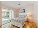 Bright bedroom with wood floors, ceiling fan, and sliding glass door to outdoor space at 1110 Southlake Ct, Venice, FL 34285