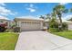 Charming home featuring a two-car garage, lush landscaping, and well-manicured lawn and garden at 1110 Southlake Ct, Venice, FL 34285