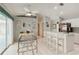 Bright kitchen with stainless steel appliances, white cabinetry, bar seating and breakfast nook with a glass table at 1110 Southlake Ct, Venice, FL 34285